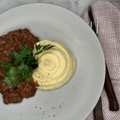 Boeuf Bourguignon upplagt på en tallrik som ett serveringsförslag. Toppad med persilja.