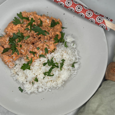 Korv stroganoff och ris ligger upplagt på en tallrik och fotat ovanifrån.