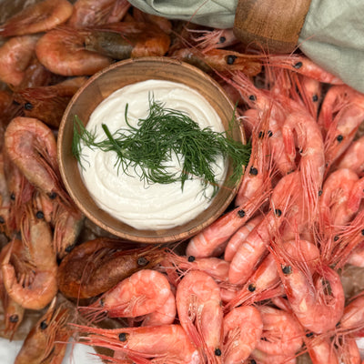 Rökta och färska räkor ligger upplagt som ett serveringsförslag tillsammans med en skål aioli.