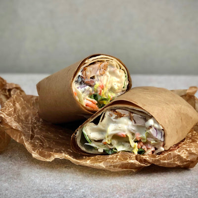 Ceasarwrap uppskuren på mitten och ligger på vaxat bakplåtspapper