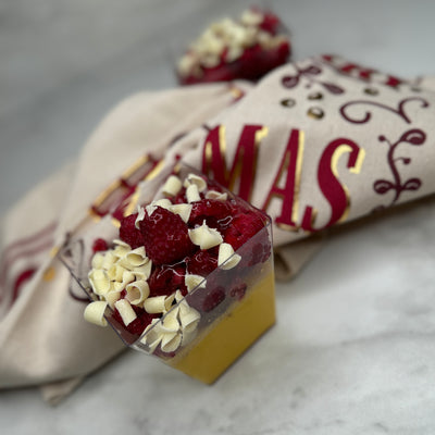 Saffranspannacotta i en plastkopp fotad från sidan så man ser den gula pannacottan med en handduk för miljö.
