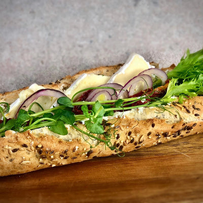 Vegetarisk baguette fotad snett uppifrån som gör att man kan se allt innehåll i baguetten.