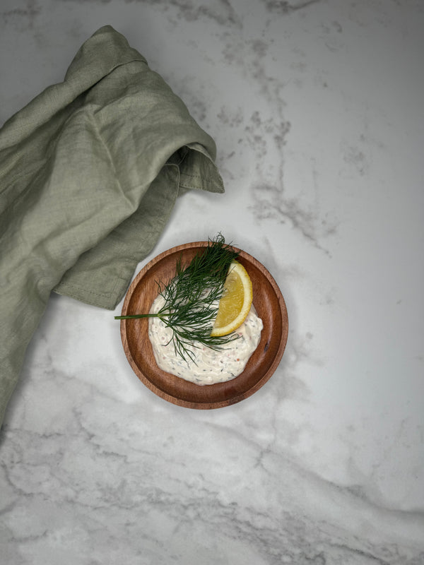Romsås i en skål toppad med dill och citron. Fotad ovanifrån.
