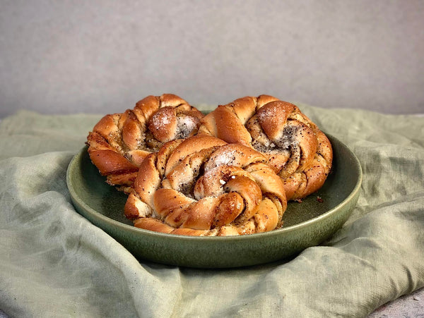 Kardemummabullar ligger i en tallrik och är fotade från sidan.