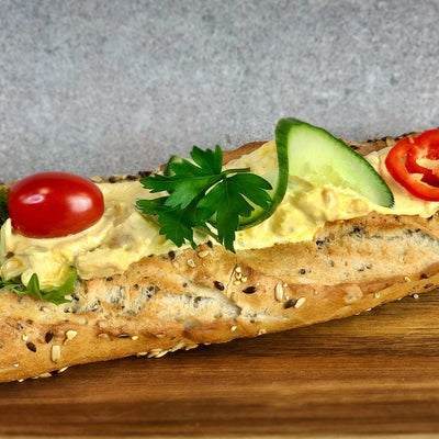 Kycklingröra baguette fotad snett uppifrån så att man kan se allt innehåll i baguetten