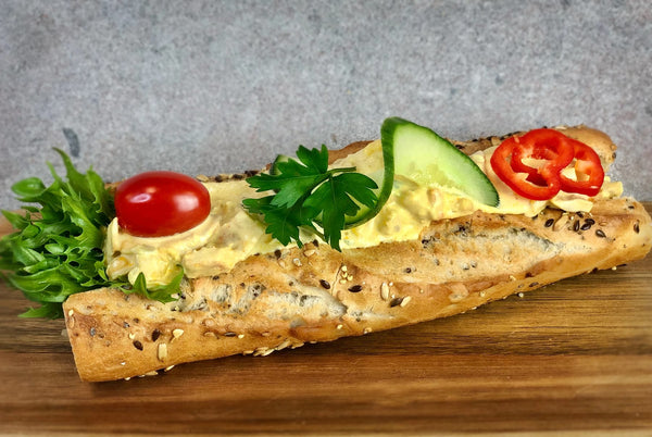 Kycklingröra baguette fotad snett uppifrån så att man kan se allt innehåll i baguetten