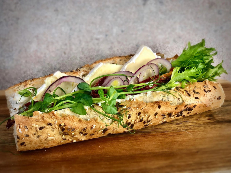 Vegetarisk baguette fotad snett uppifrån som gör att man kan se allt innehåll i baguetten.